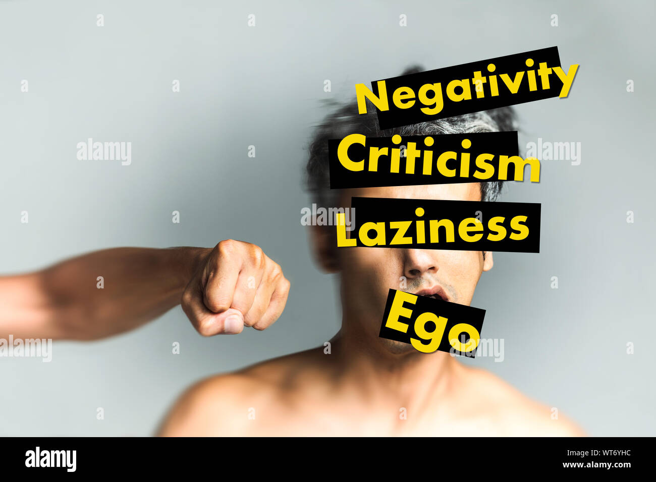 hand punching a face with yellow text on it saying negativity, criticism, laziness, ego - Life improvement concept - Personal Growth - Productive mind Stock Photo