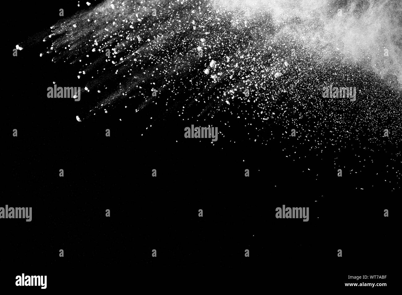 White powder explosion isolated on black background. White dust ...