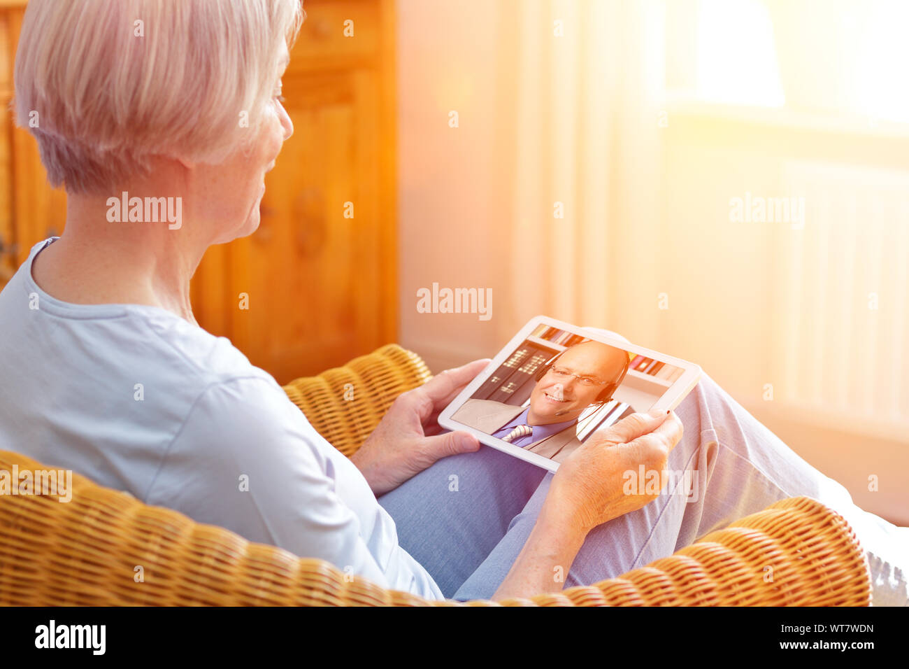 Senior people e-learning concept, old woman with tablet pc at home during an online lesson with her language teacher Stock Photo