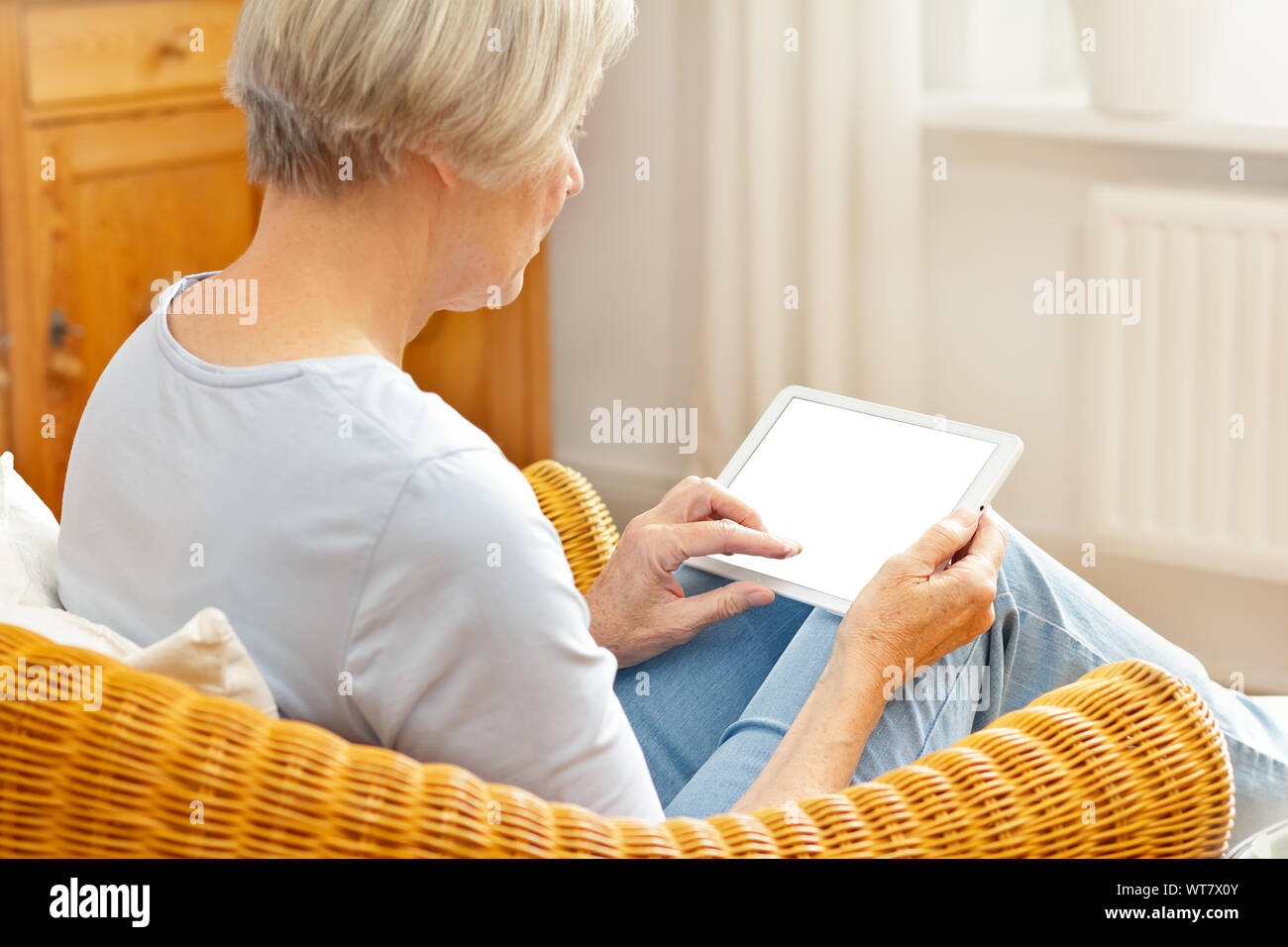technology and senior people concept, elderly woman with tablet computer at home, touching blank screen Stock Photo