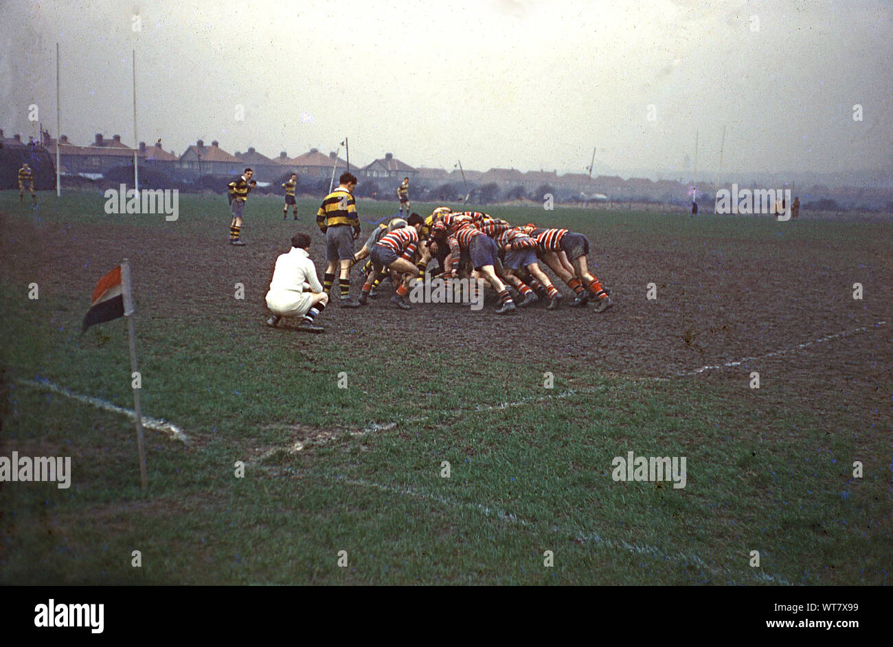 1960s, historical, amateur rugby union match at Wallasey, Wirral, England UK, outside on a muddy pitch, male players crouched down in a scrum watched by the referee. Stock Photo