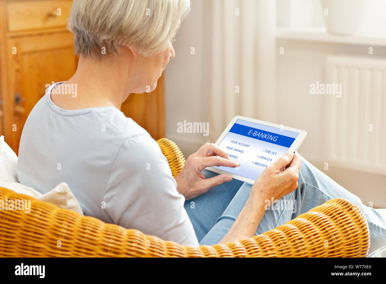 Senior people and online banking concept, elderly woman with tablet computer at home, touching screen Stock Photo