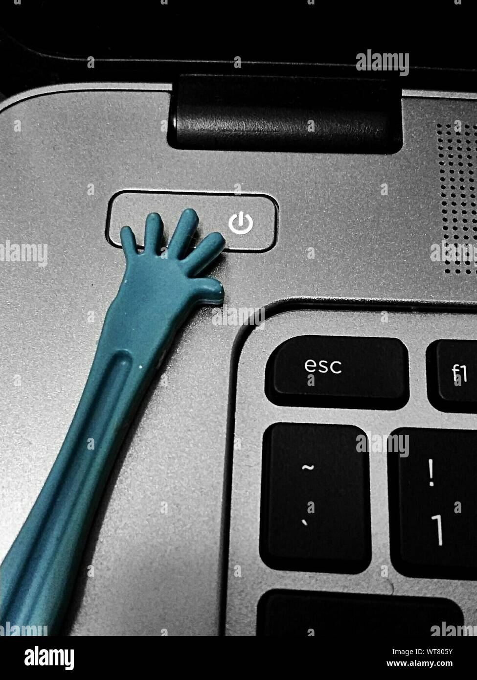 Plastic Hand On Power Button Of Laptop Stock Photo