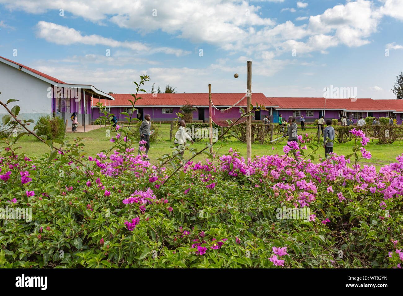 Imani Junior Academy, Nanyuki, Laikipia county, Kenya – June 13th, 2019: Candid photograph of young school children playing volleyball in field at Ima Stock Photo