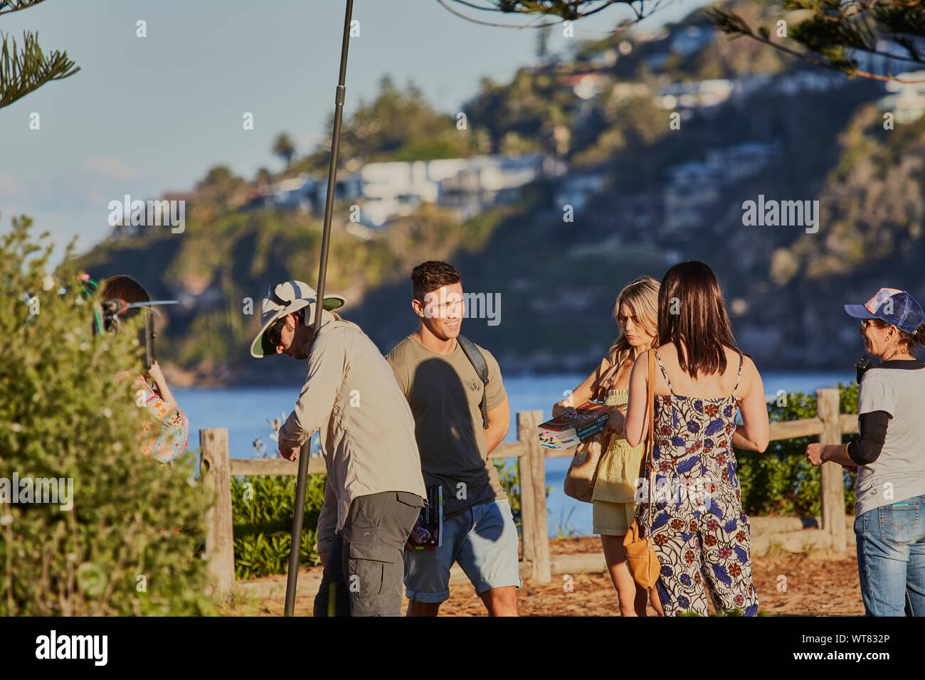 Actors and crew including a sound boom operator filming an outdoor scene of Home & Away television programme at Palm Beach, New South Wales, Australia Stock Photo