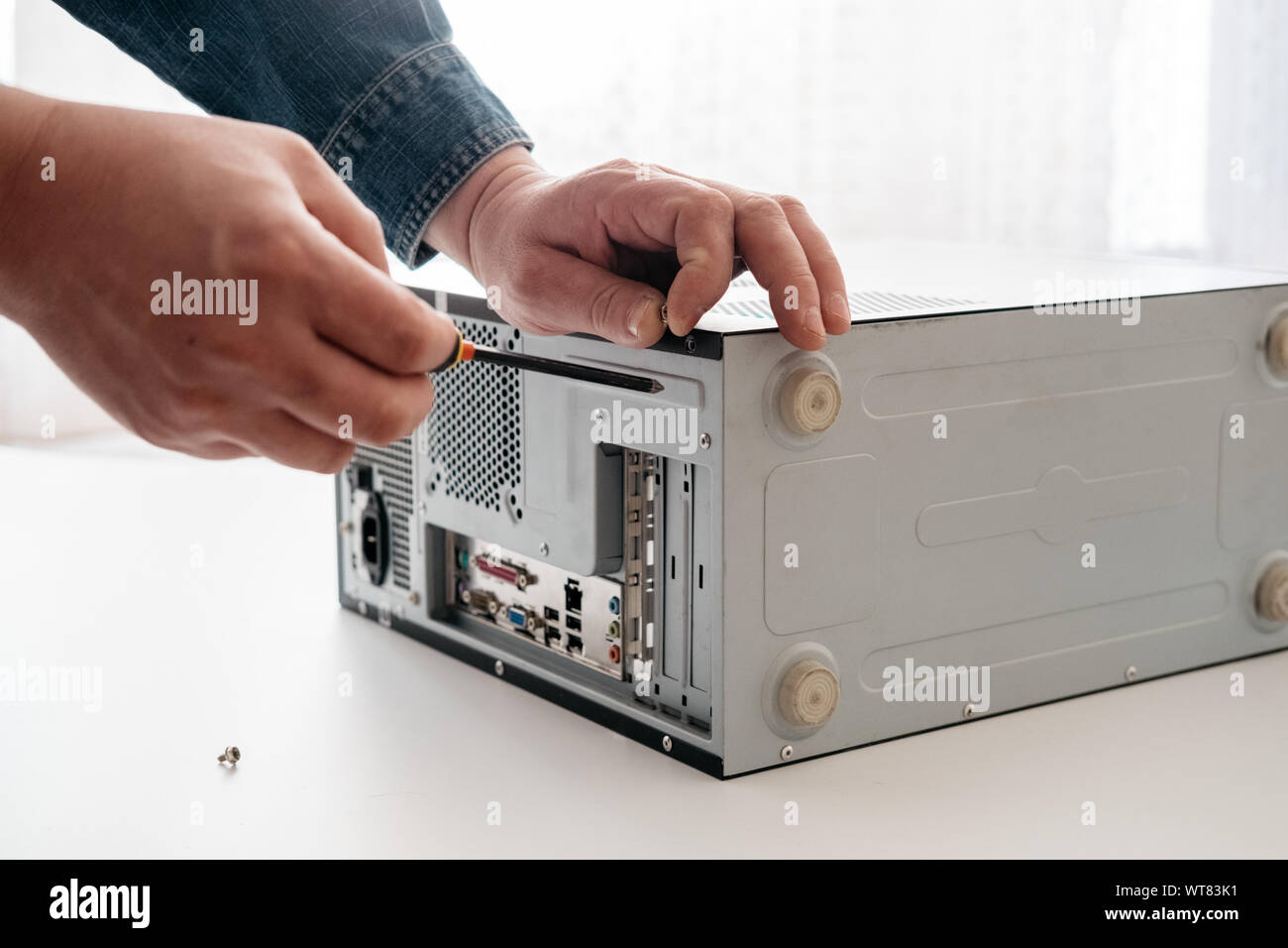 Technician disassemble computer with a screwdriver for problems