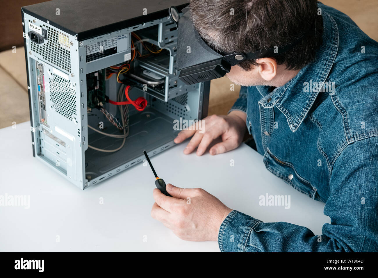 Repairman is disassembling personal computer. Engineer is diagnostic and fixing broken pc in workshop. Electronic repair shop, technology renovation, Stock Photo