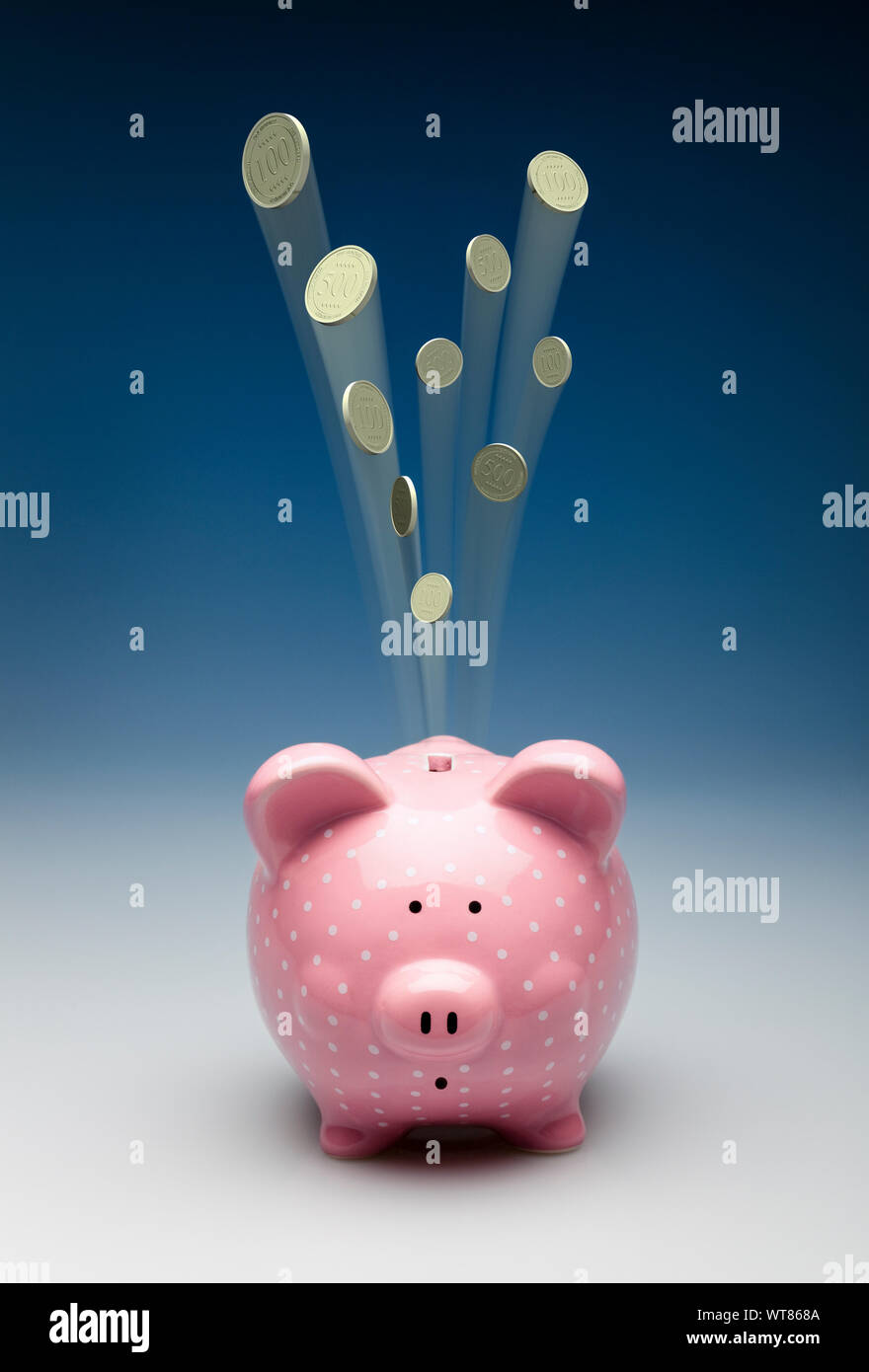 Pink piggy bank with gold coins shooting out of it, spending or loss concept Stock Photo