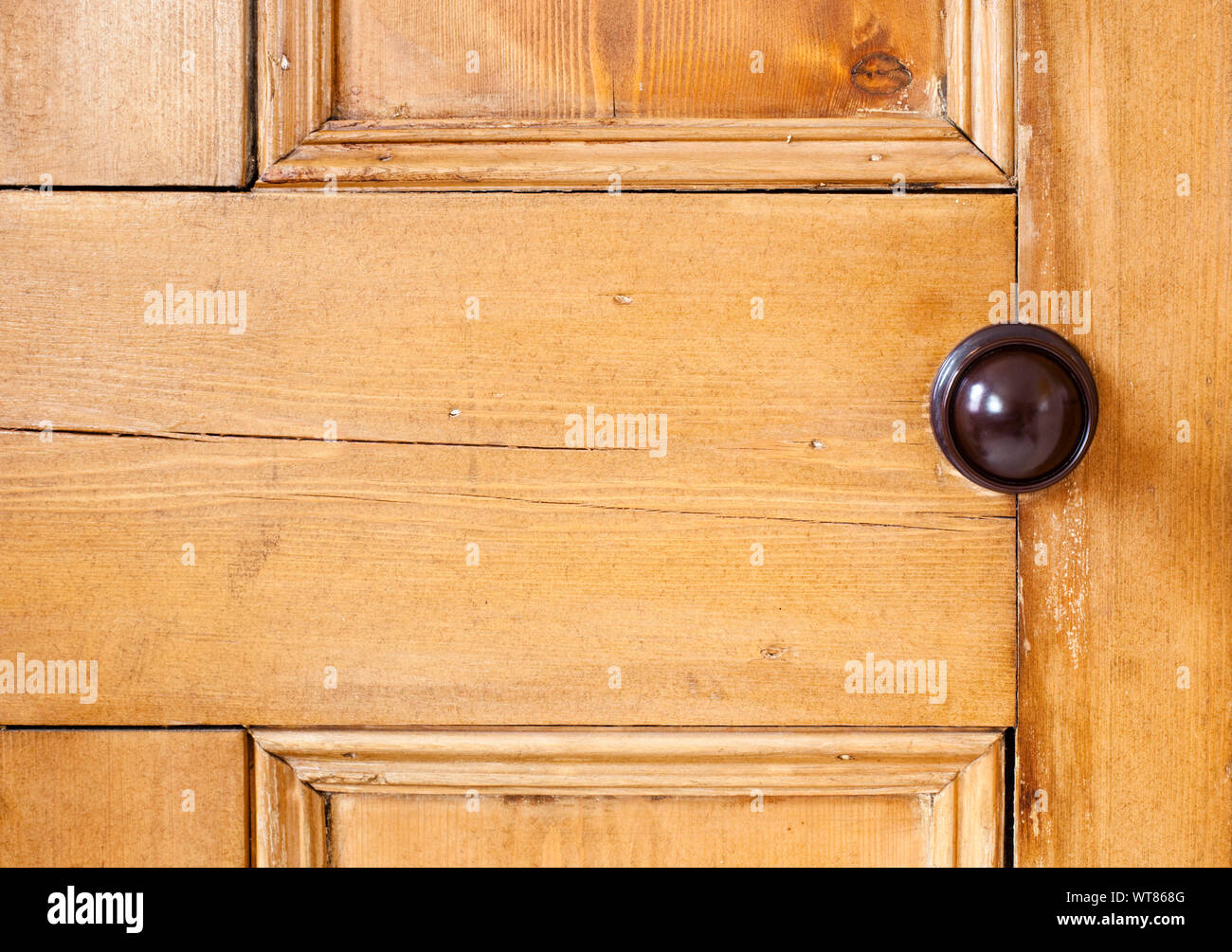 Section of an old wooden internal door with a bakelite door knob Stock Photo