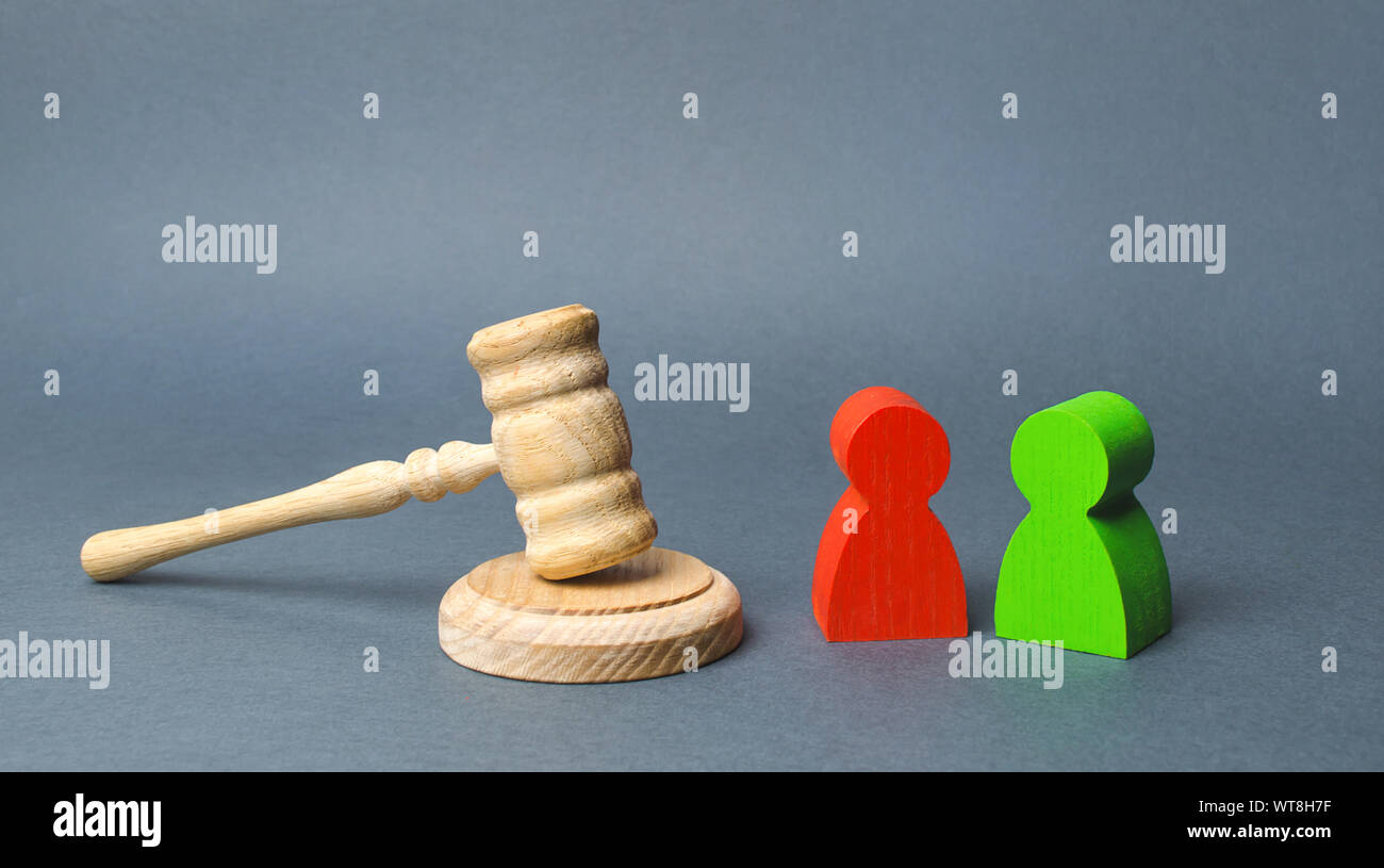 Two figures of people opponents stand near the judge's gavel. The judicial system. Conflict resolution in court, claimant and respondent. Court case, Stock Photo