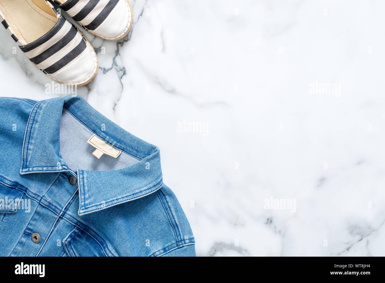 Border frame of striped sandals and jeans jacket on marble background. Trendy flat lay composition, casual clothing of beauty fashion blogger, fashion Stock Photo