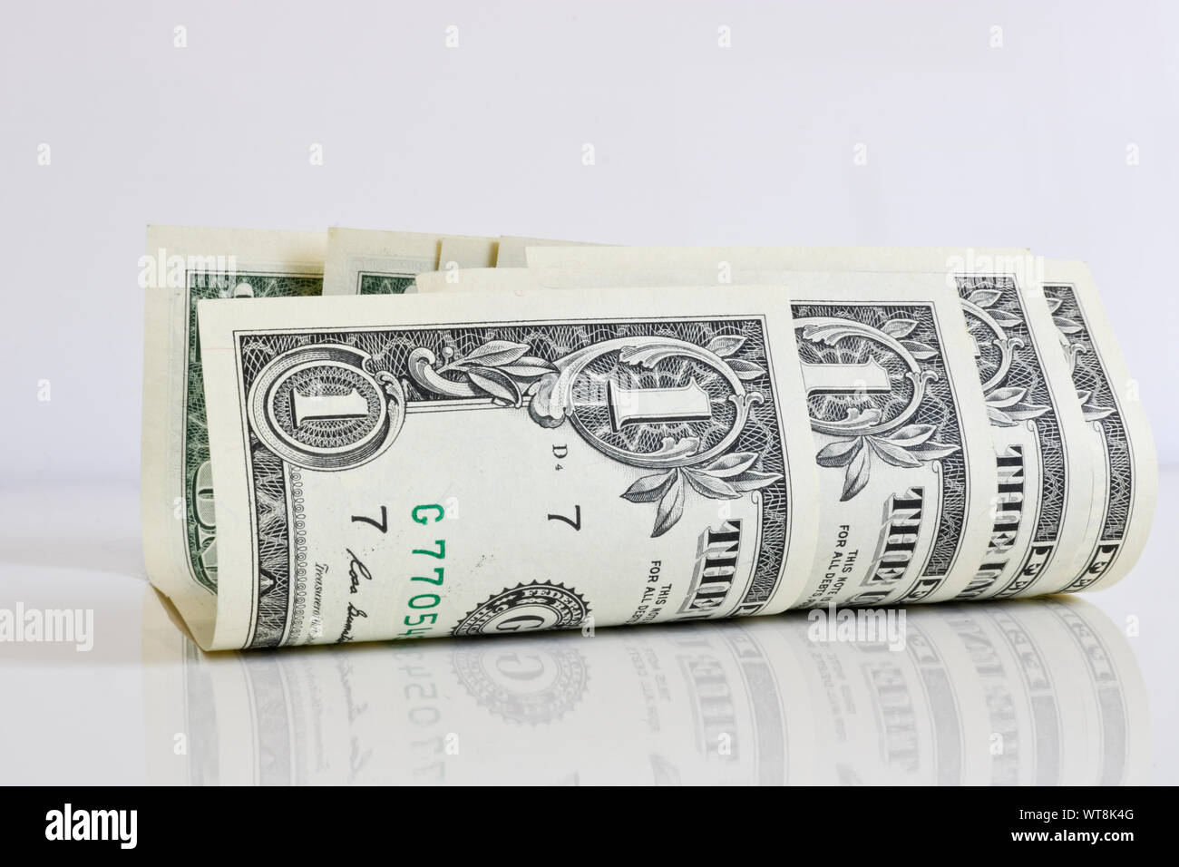 A little curled one-dollar bills on a light background close-up ...