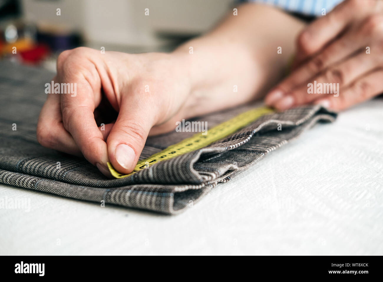 tailor using a measure tape to measure width of pants Stock Photo Alamy
