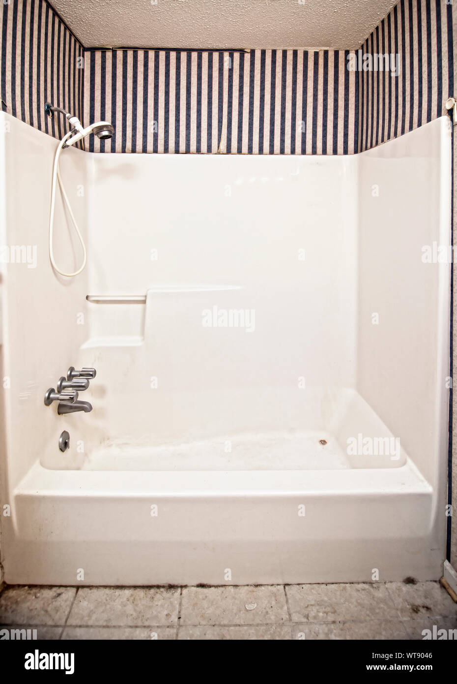 filthy tub, shower and bathroom with peeling wallpaper Stock Photo Alamy