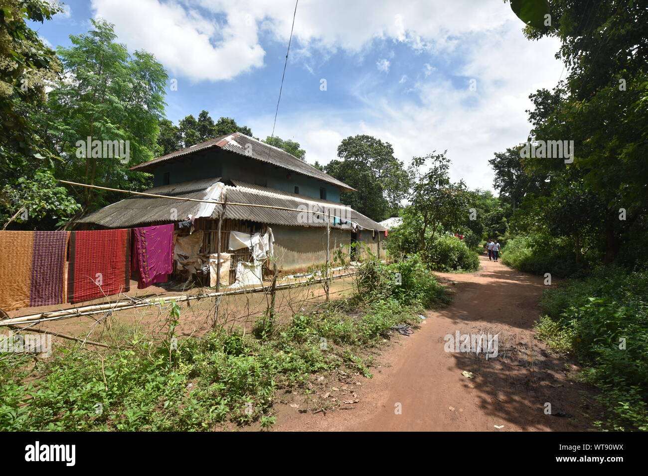 Two-story mud house with countryside road. Village Banstala, Jhargram, West Midnapore, India. Stock Photo