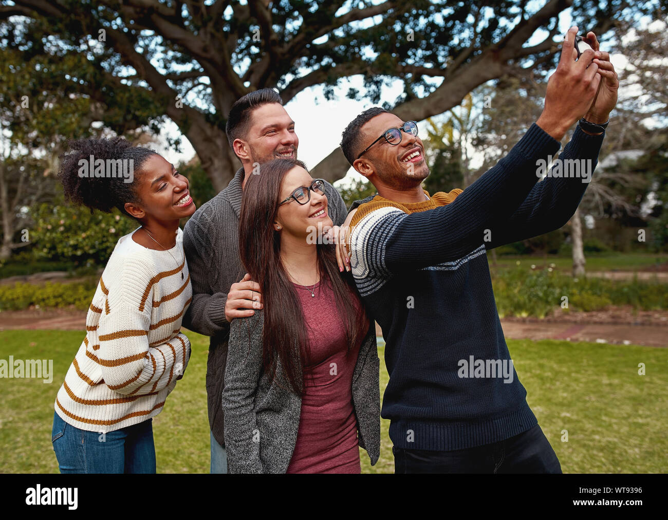 Group Of Multiracial Young Friends Standing Together In A Green Park 