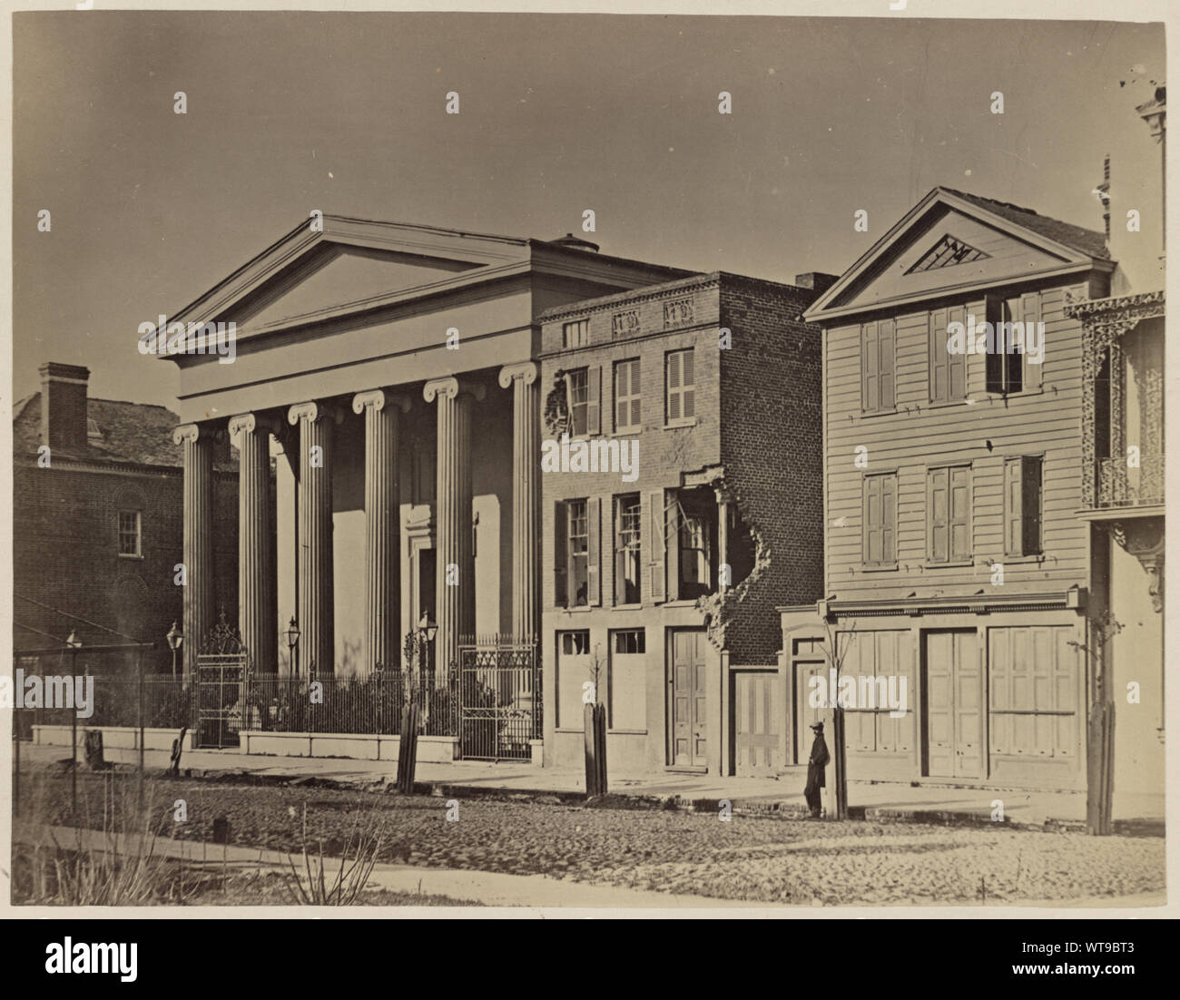 Meeting Street, Charleston, S.C  Photograph shows shell damaged buildings on Meeting Street with Hibernian Hall on the left. At far right is the St. John Hotel balcony. Stock Photo