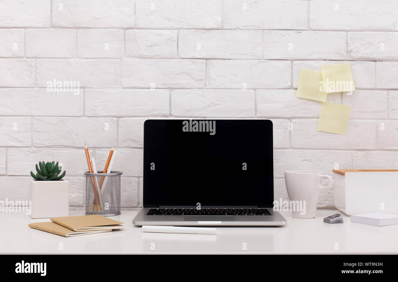Laptop with blank screen for site on office table with supplies Stock ...