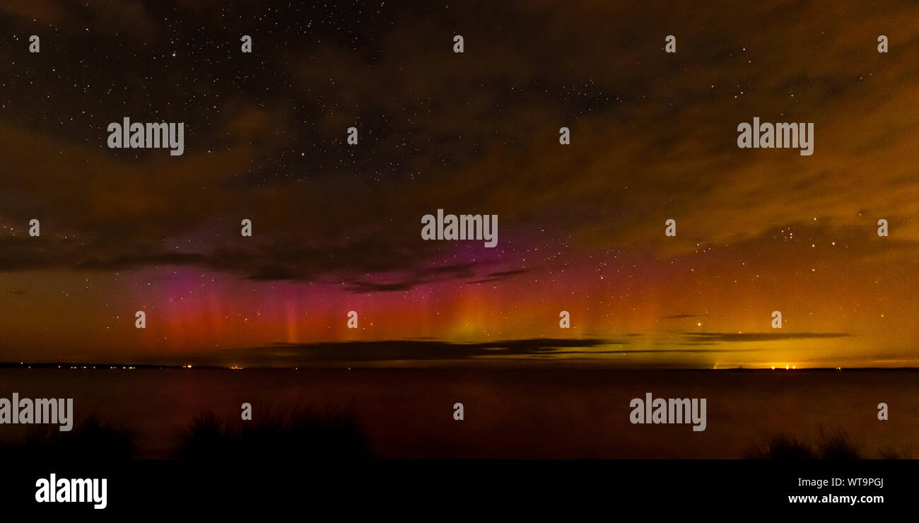 Colorful Northern Lights (Aurora Borealis)  and stars over the Grand Traverse Bay of Lake Michigan near Traverse City. Stock Photo