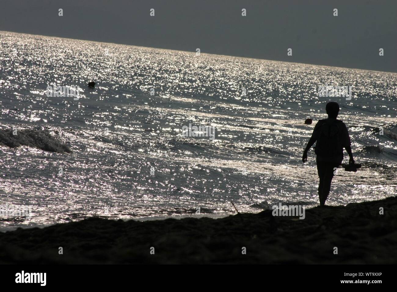 Silhouette of a woman walking on beach hi-res stock photography and ...