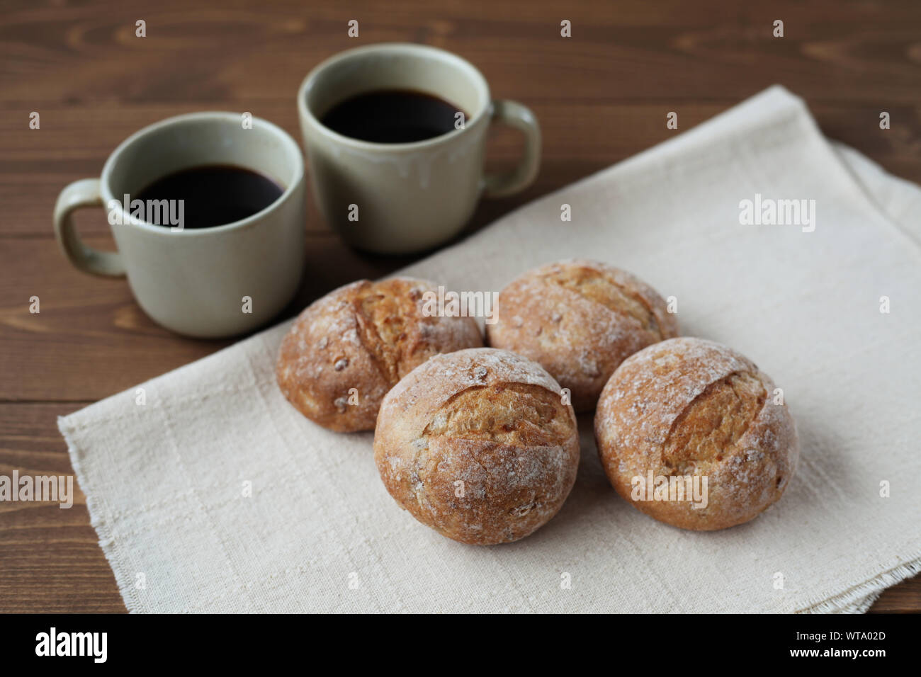 french rye bread with cups of coffee isolated on wooden table Stock Photo