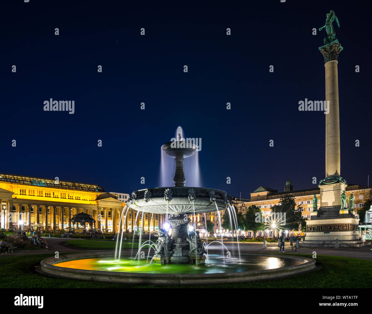 Stuttgart, Germany, August 25, 2019, Downtown schlossplatz square, palace square with illuminated water fountain next to memorial monument surrounded Stock Photo