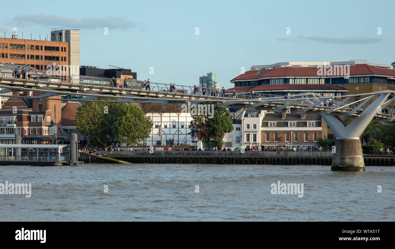 World-famous Shakespeare's Globe Theatre seen under the Millennium pedestrian Bridge in the evening sun on the bank of the river Thames. Stock Photo
