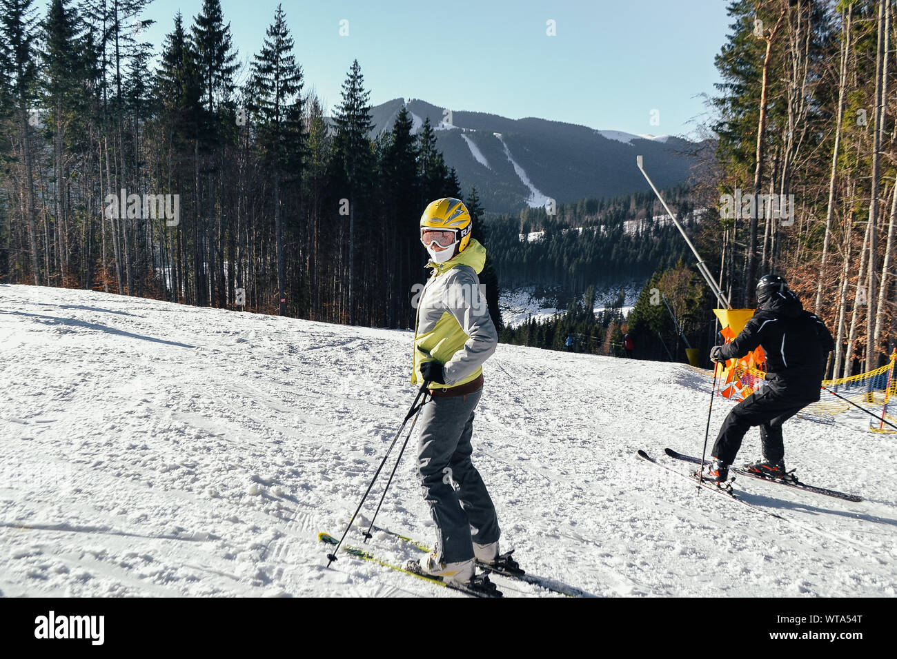 Bukovel, Ukraine. 2, 2017 A skier rides in beautiful sunny weather in winter on the side of a mountain. The girl is skiing looking in the frame. Resor Stock Photo