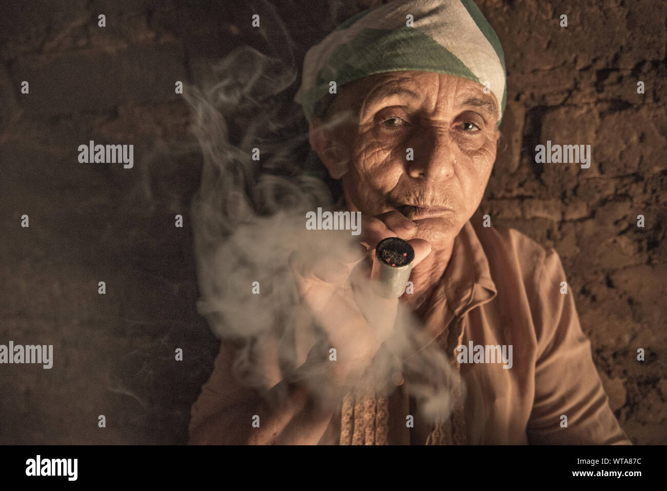 Old woman smokes pipe in her house in northern Brazil Stock Photo