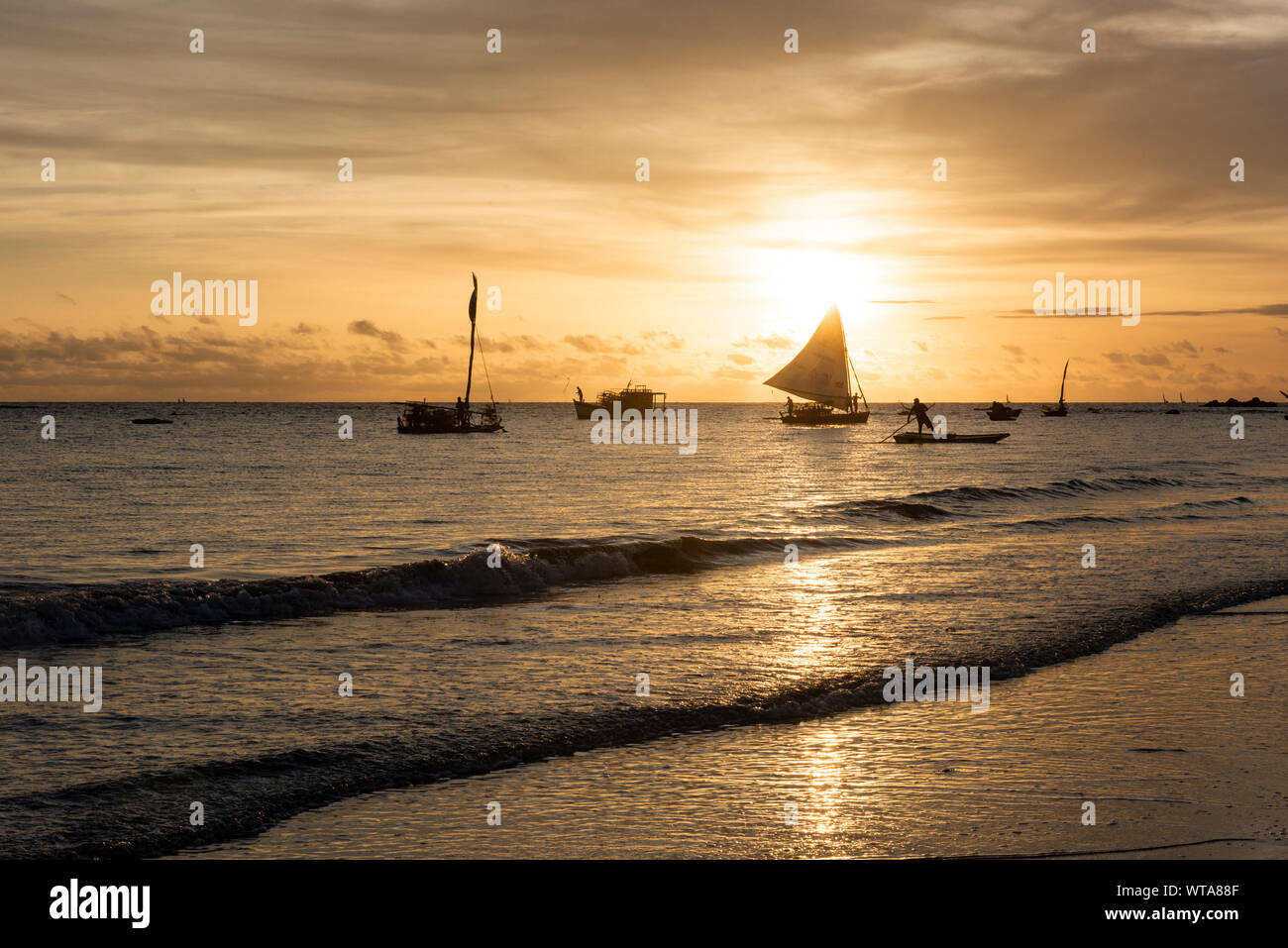 Fisherman on boat during sunrise at Praia da Redonda Stock Photo