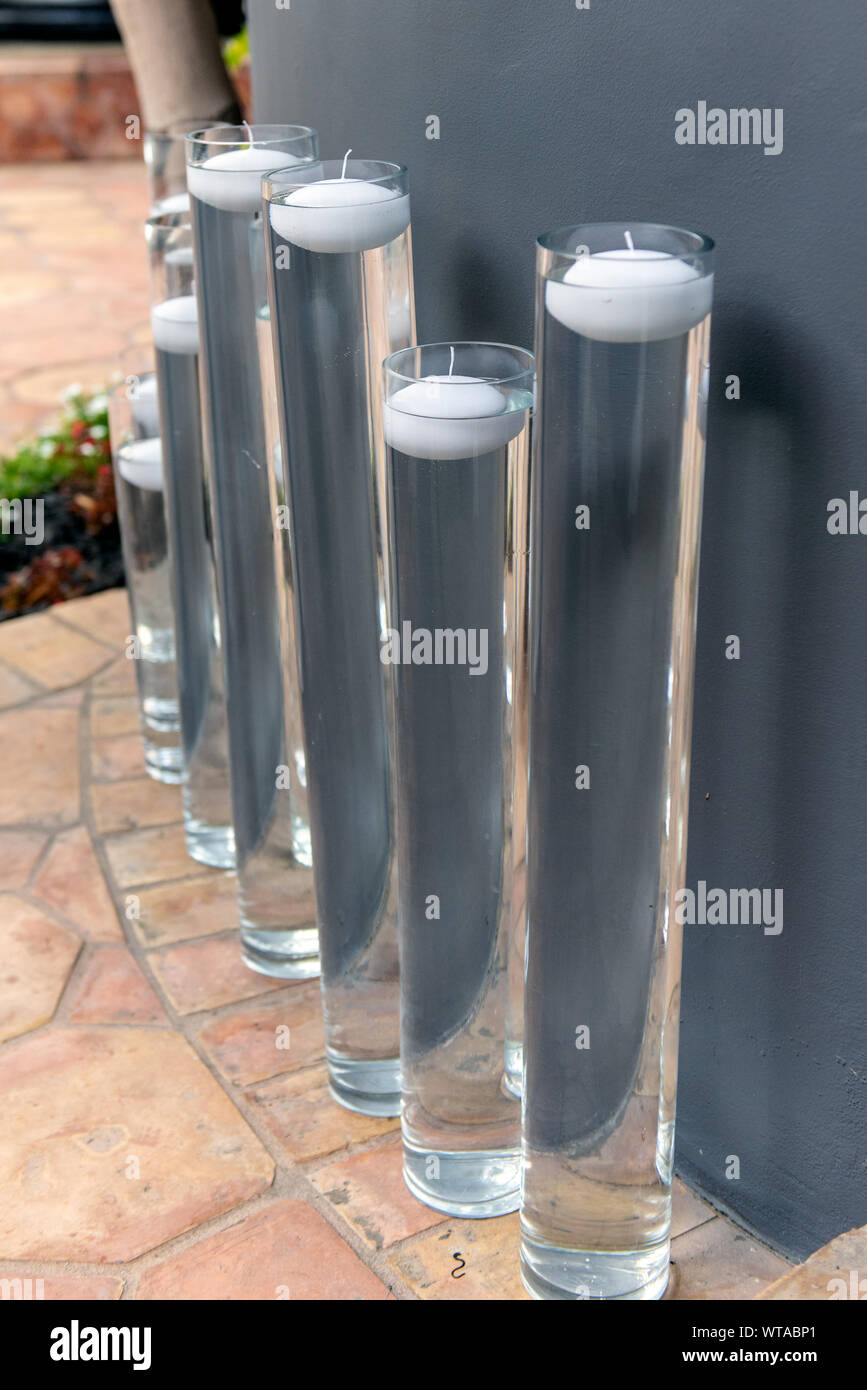 Various heights of water tubes hold outdoor floating candle decorations