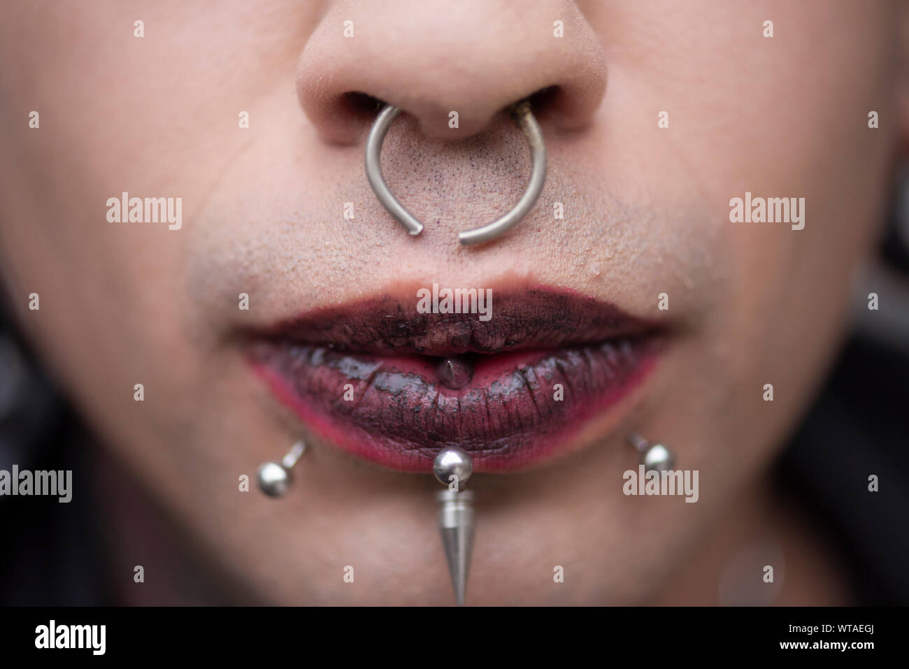 Alternative guy pierced using red lipstick Stock Photo