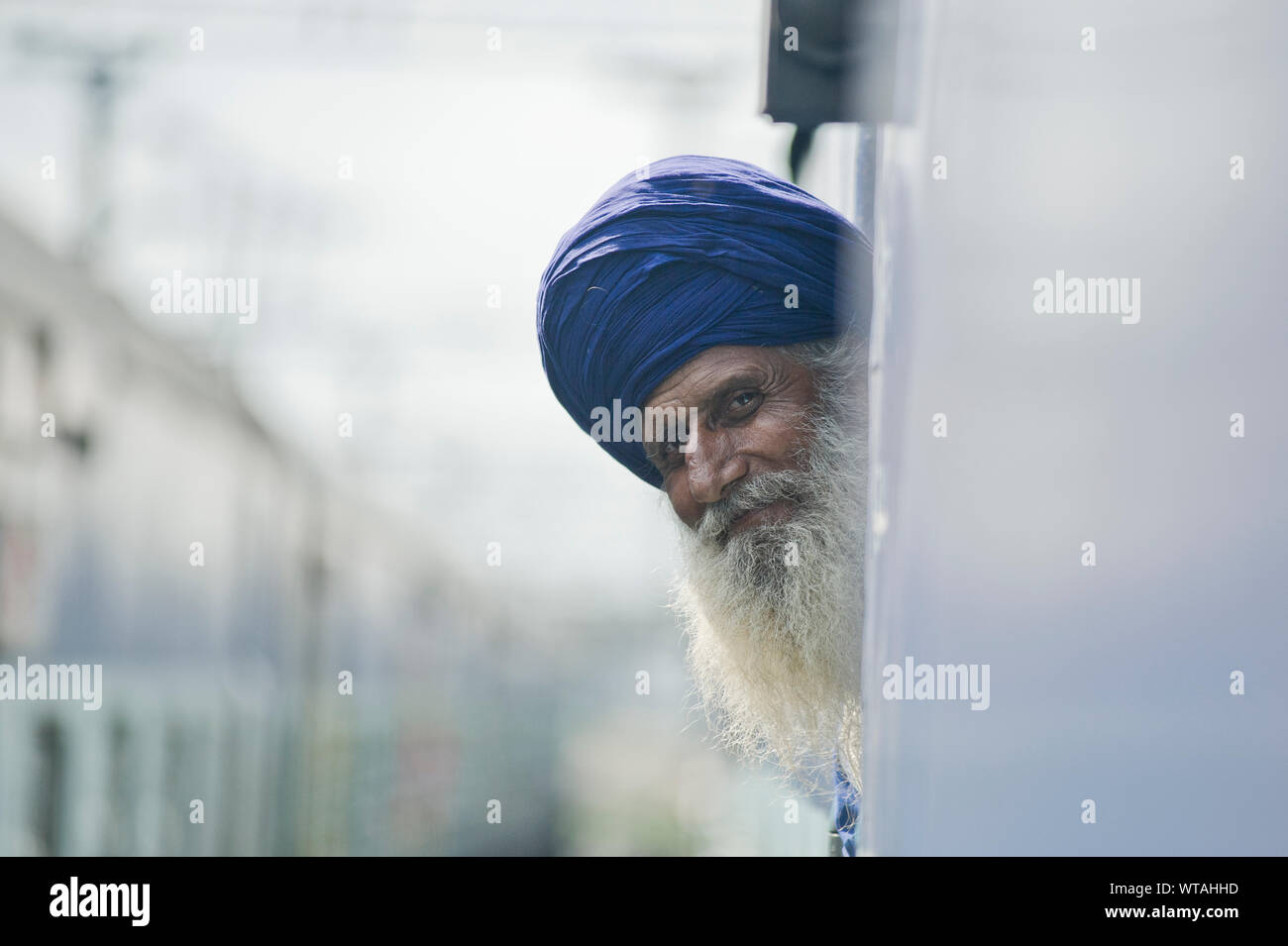 Old Sikh man looks outside a window of the train Stock Photo