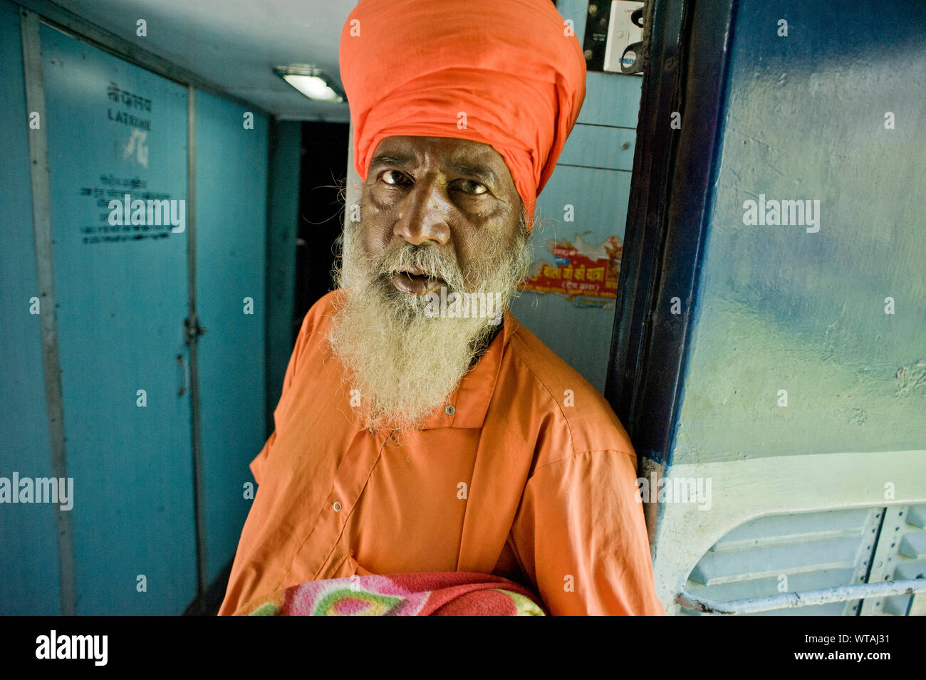 Sikh in elegant orange clothes in a train Stock Photo