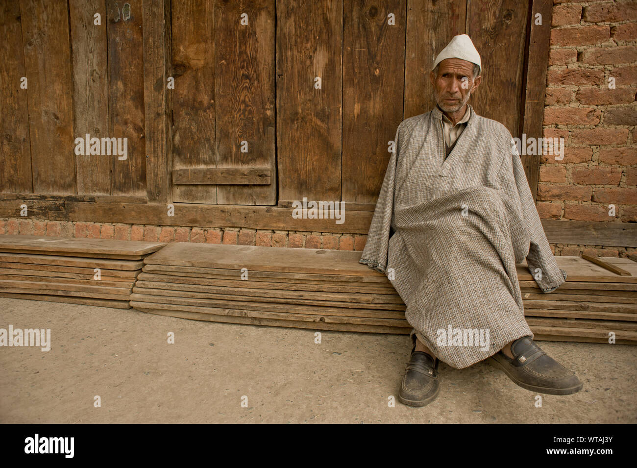 Kashmiri wearing phiran and white traditional hat Stock Photo
