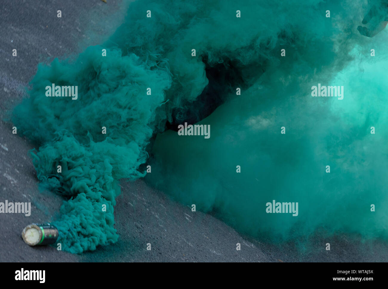 Green smoke of flare on the road, during a protest of Antifa in central London, UK Stock Photo