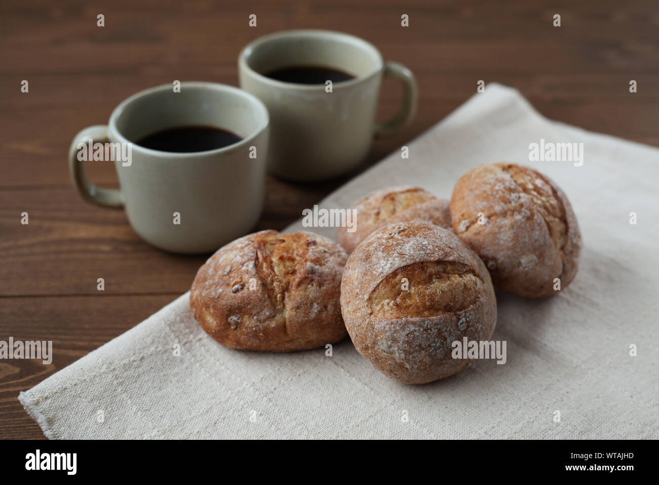 french rye bread with cups of coffee isolated on wooden table Stock Photo
