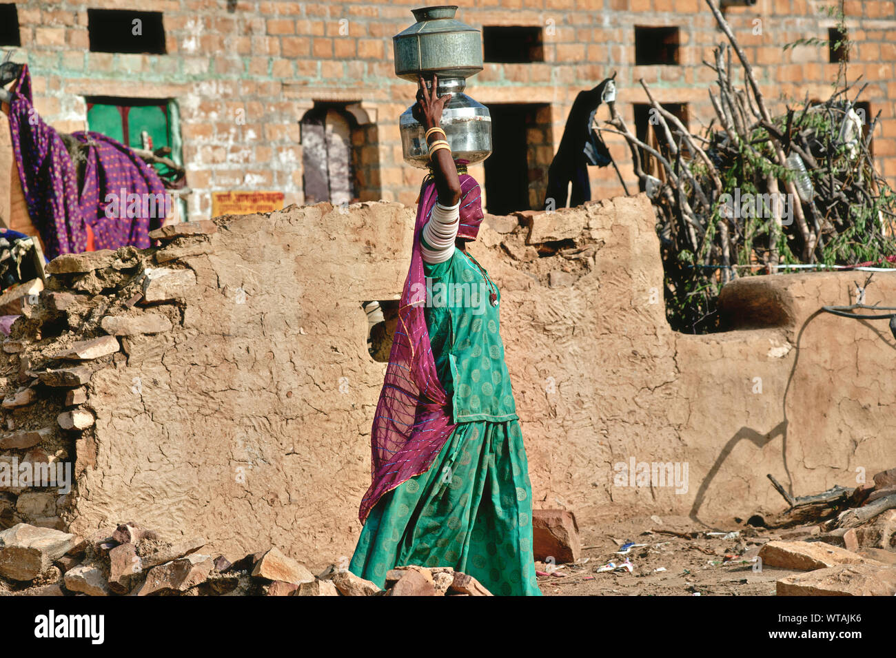 Rajasthani carrying water jars in the head in a Thar Desert village Stock Photo