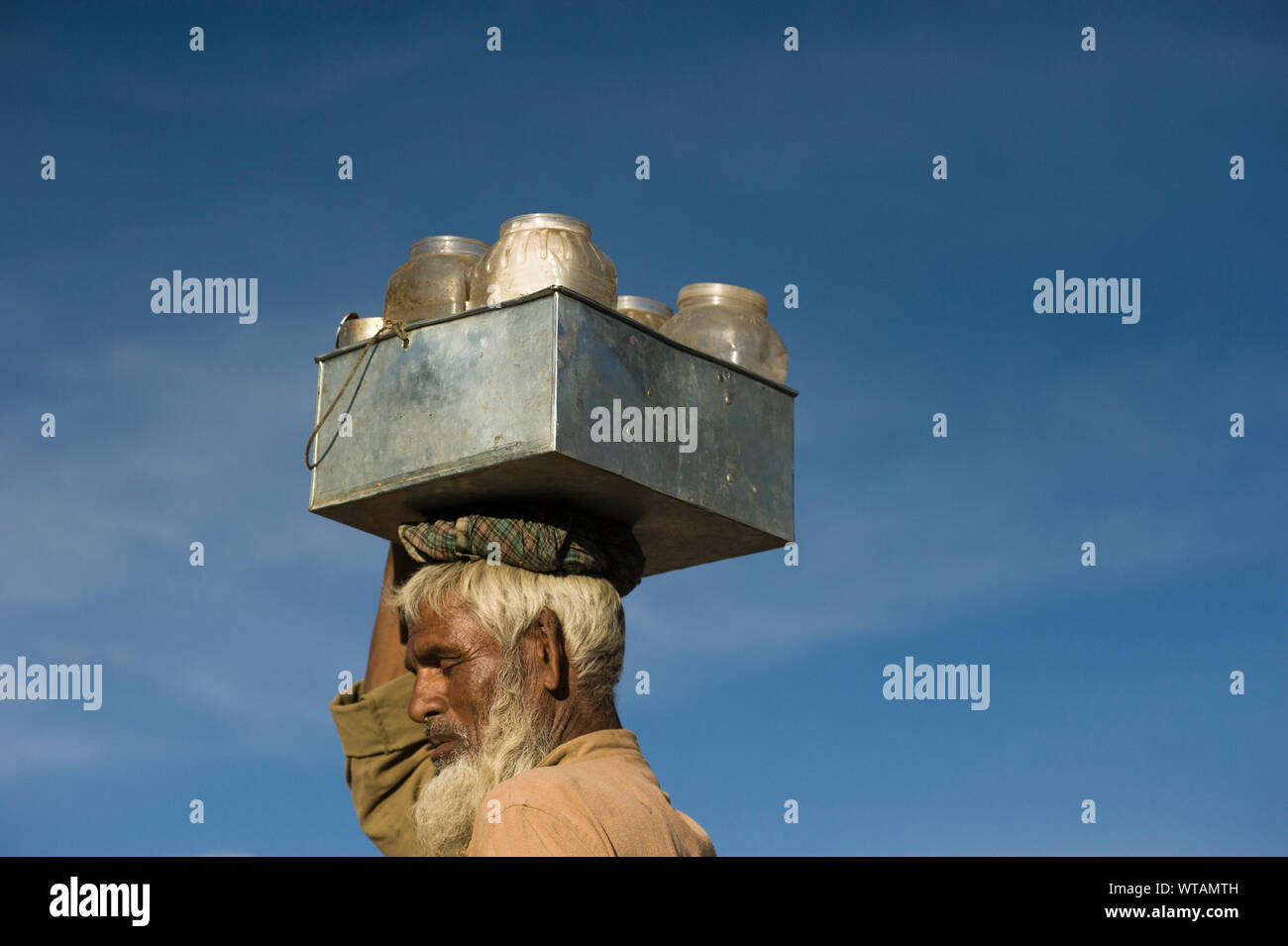 Milkman carrying milk pots in the head Stock Photo