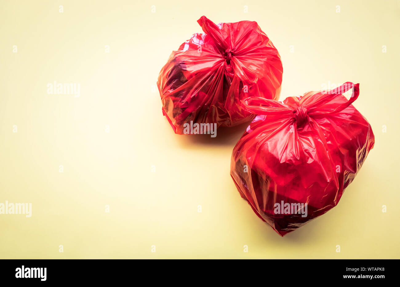 Food trash packing in red plastic bag on color background. Recycle and environment concepts ideas Stock Photo