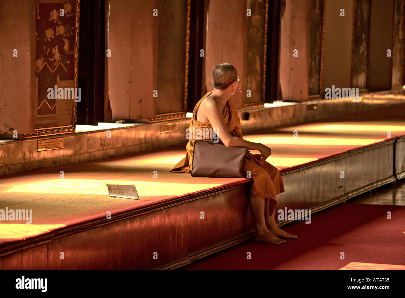 Monk seated inside a temple in Bangkok Stock Photo