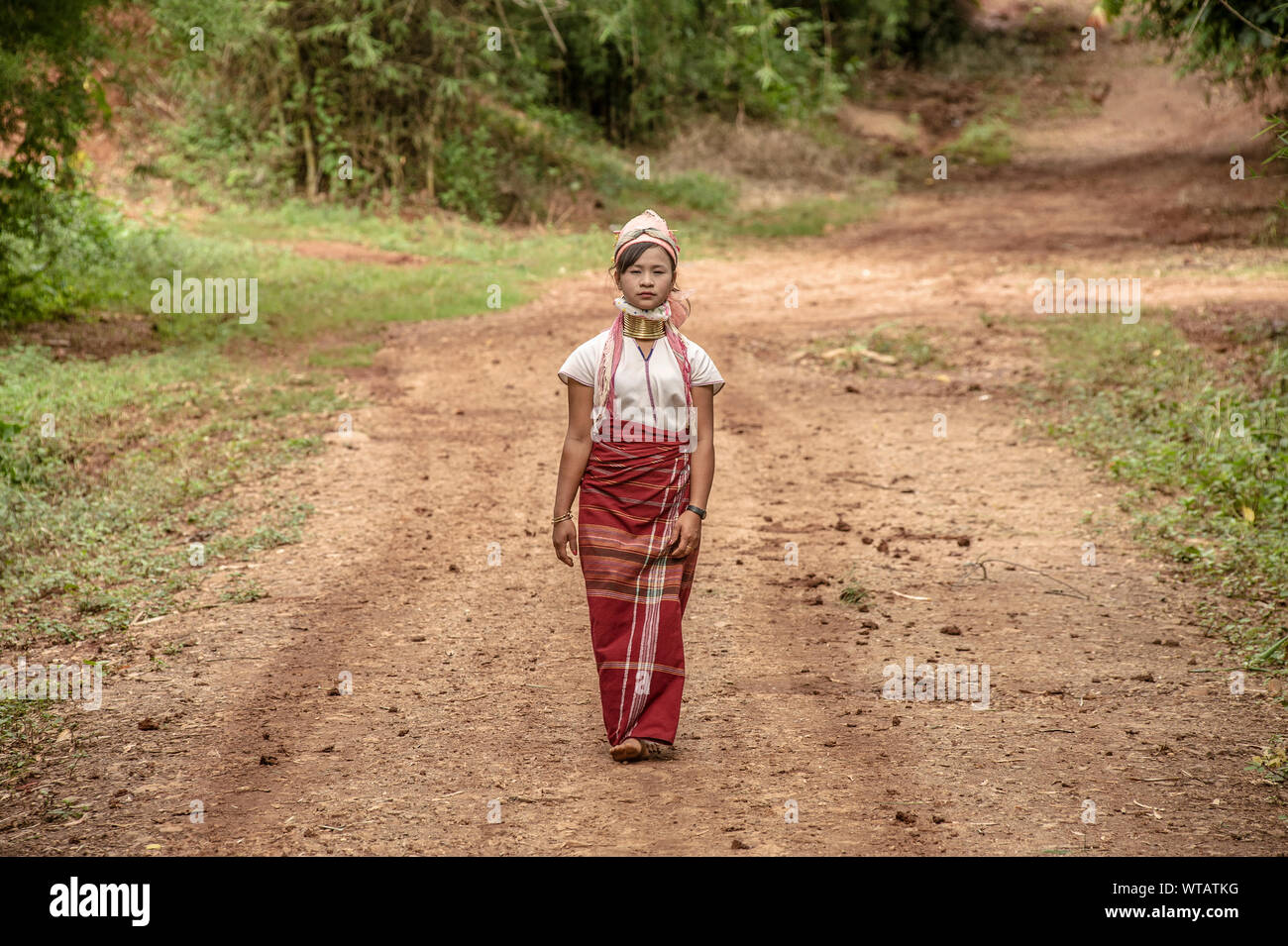 Long Neck woman walking in the tribe dirt road Stock Photo