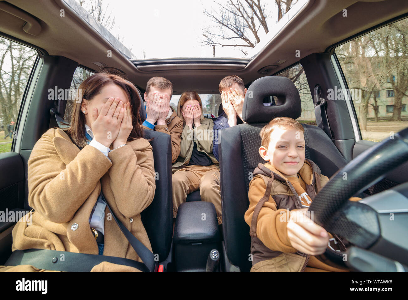 car travel fun concept. little boy driving car with adults people.  unconfident driver Stock Photo - Alamy