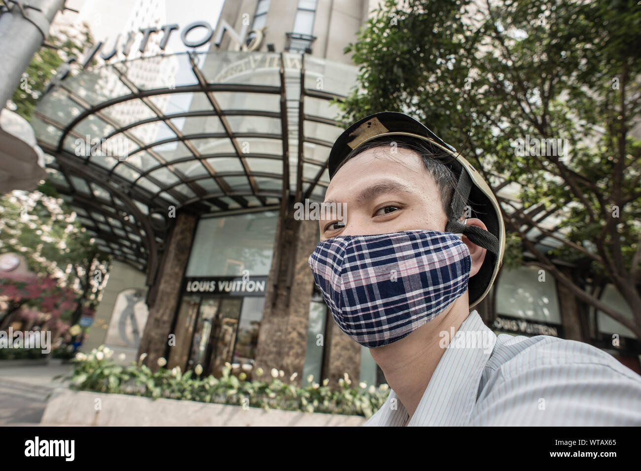 Motorcycle rider using anti-pollution mask near brand  store Stock Photo