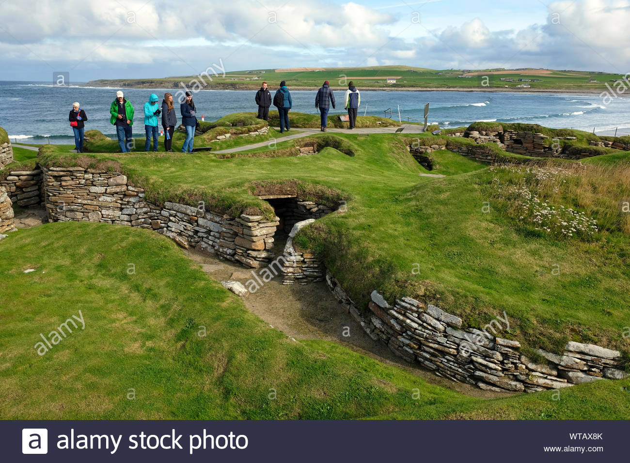 Tourists visiting Skara Brae, a stone-built Neolithic settlement, located on Mainland Orkney, Scotland Stock Photo