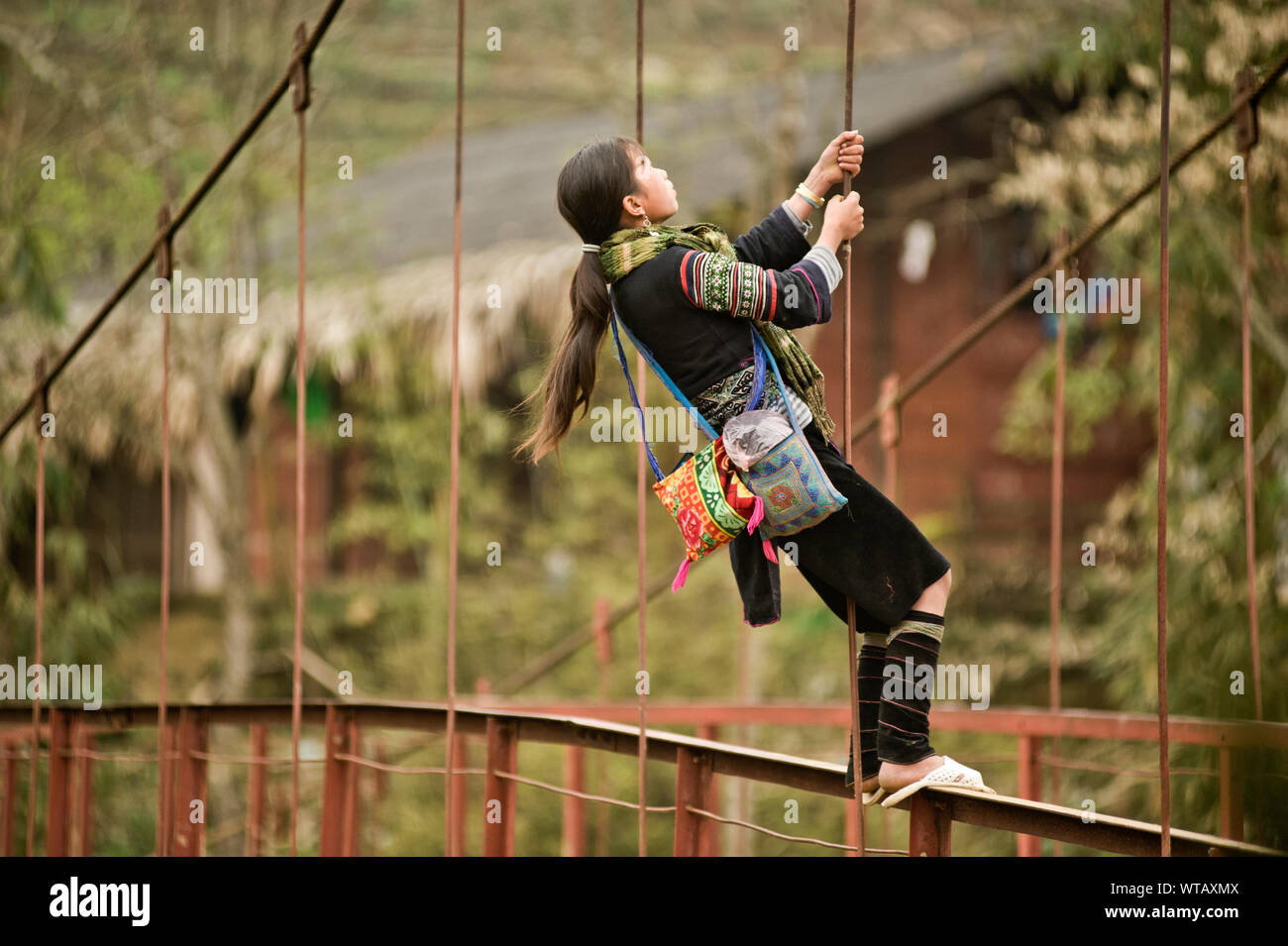 Hmong girl playing in the village bridge Stock Photo