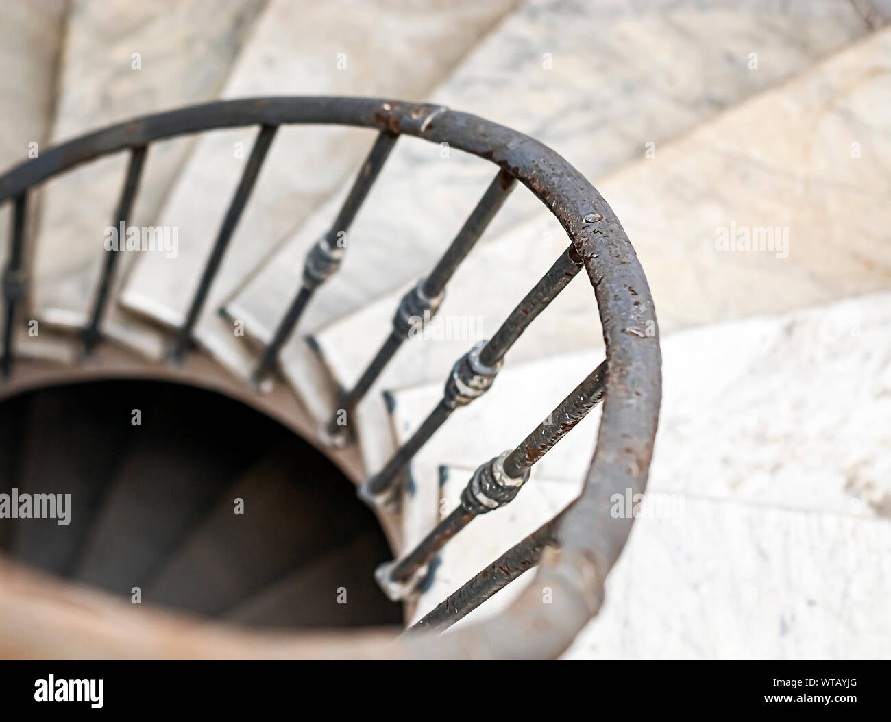 ancient spiral staircase with marble steps and wrought iron handrail. Architecture and circular shape Stock Photo