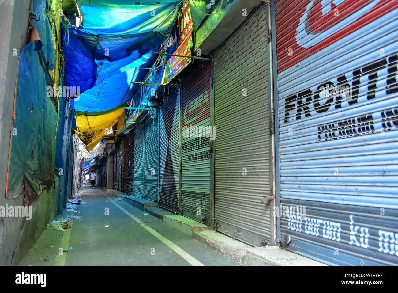 A man walks past closed shops during a shutdown in Srinagar, Kashmir.Kashmir valley remained shut for the 38th consecutive day following the scrapping of Article 370 by the central government which grants special status to Jammu & Kashmir. Stock Photo