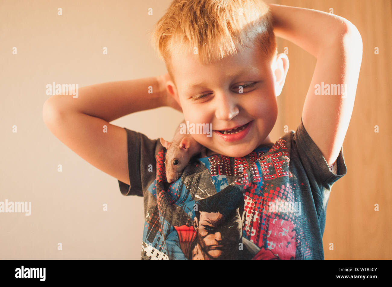 LOS ANGELES, CA, USA - AUGUST 28, 2019: A 5 year old child plays with a rat sphinx. A bald rat sits on a child s shoulder, illustrative editorial Stock Photo