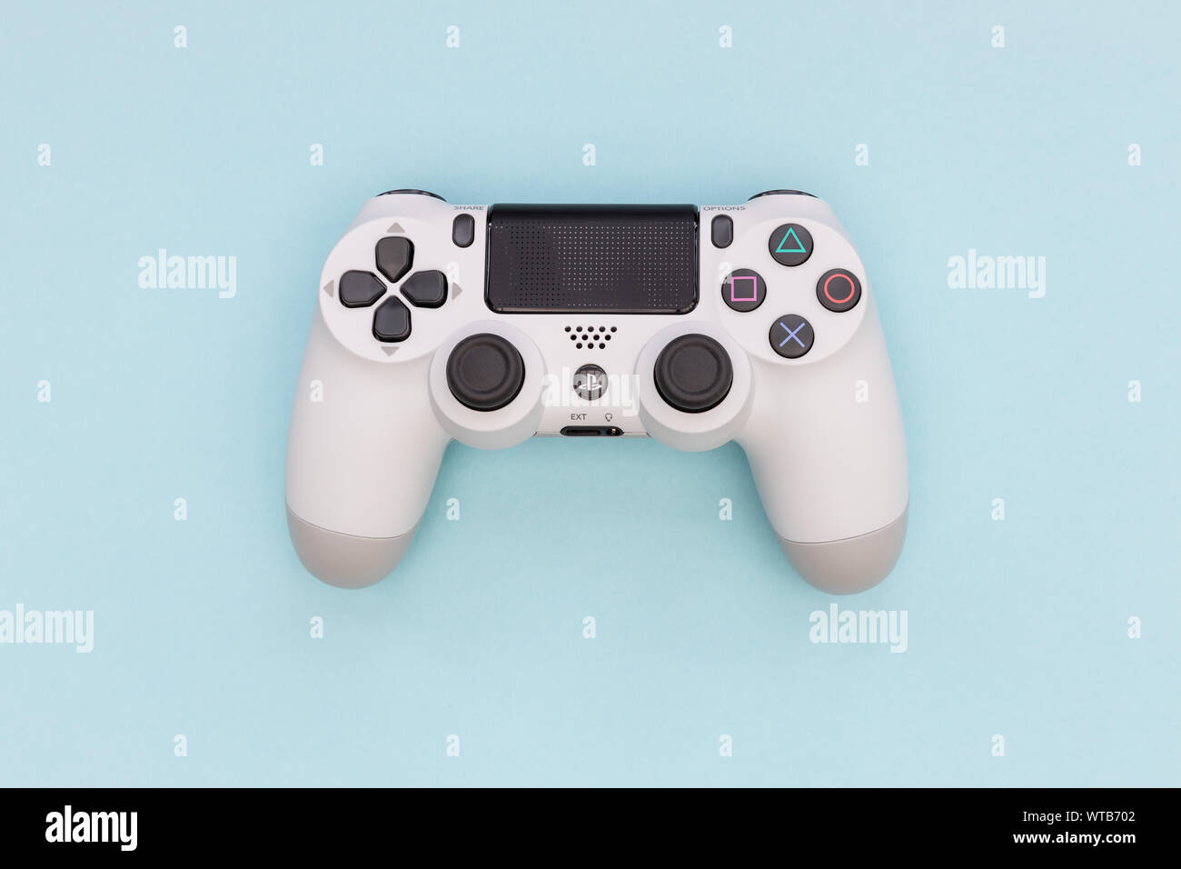 LONDON - SEPTEMBER 06, 2019: Video games PlayStation white gaming controller isolated on blue color background top view Stock Photo
